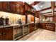 Dark wood kitchenette area with stainless steel appliances, granite countertops, and under cabinet lighting at 2823 Providence Rd # 156, Charlotte, NC 28211