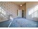 Bedroom with blue carpet, vintage wallpaper, and a radiator heater at 303 Wade St, Wadesboro, NC 28170