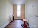 Empty bedroom features a radiator, hardwood floors, large window and table at 303 Wade St, Wadesboro, NC 28170