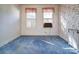 Bedroom with blue carpet, floral wallpaper, and two bright windows at 303 Wade St, Wadesboro, NC 28170