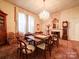 Elegant dining room with a chandelier, large windows, and ornate wallpaper at 303 Wade St, Wadesboro, NC 28170