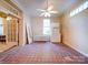 Empty room with red tiled floor, ceiling fan, and access to other rooms at 303 Wade St, Wadesboro, NC 28170