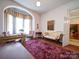 Living room with a red rug, hardwood floor, curtains, and neutral walls at 303 Wade St, Wadesboro, NC 28170