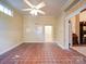 Empty room with red tiled floor, ceiling fan, and access to other rooms at 303 Wade St, Wadesboro, NC 28170