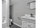 Bright bathroom features a toilet and a vanity with white basin and gray flooring at 315 E Washington Ave, Bessemer City, NC 28016