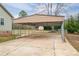 View of the property's concrete carport and grassy backyard enclosed by a chain link fence at 3155 Ramseur St, Lincolnton, NC 28092