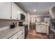 Efficient kitchen featuring granite countertops, white cabinets, stainless appliances, and an open view into the dining area at 3155 Ramseur St, Lincolnton, NC 28092