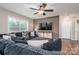 Comfortable living room with a large sectional sofa, ceiling fan, modern entertainment center, and wood-look flooring at 3155 Ramseur St, Lincolnton, NC 28092