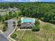 Aerial view of a pool and clubhouse surrounded by trees and a parking lot, plus neighborhood views at 325 Ox Bow Cir, Mount Holly, NC 28120