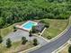 Aerial view of the pool and clubhouse surrounded by mature trees and other neighborhood amenities at 325 Ox Bow Cir, Mount Holly, NC 28120