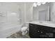 Bright bathroom featuring a shower and tub, along with a dark vanity, toilet, and modern fixtures at 325 Ox Bow Cir, Mount Holly, NC 28120