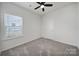 Bedroom with carpet, a window, ceiling fan, and a closet or bathroom doorway at 325 Ox Bow Cir, Mount Holly, NC 28120