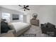 Staged bedroom with a large bed, dresser with a round mirror, and a gray armchair at 325 Ox Bow Cir, Mount Holly, NC 28120