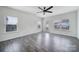 Bright living room with hardwood floors, a modern ceiling fan, and abundant natural light from several windows at 325 Ox Bow Cir, Mount Holly, NC 28120