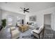 Staged living room with a modern ceiling fan, and abundant natural light streaming through the windows at 325 Ox Bow Cir, Mount Holly, NC 28120