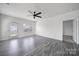 Bright living room features hardwood floors, a modern ceiling fan, and abundant natural light from the windows at 325 Ox Bow Cir, Mount Holly, NC 28120