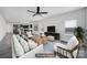 Staged living room showcases kitchen and dining area, modern ceiling fan, and natural light at 325 Ox Bow Cir, Mount Holly, NC 28120