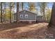 Back exterior of a gray home, featuring brick foundation accents and autumnal foliage at 325 Spring Oak Dr, Salisbury, NC 28147