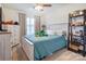 Inviting bedroom features a ceiling fan, a large window, and a cozy blue bedspread at 3941 Rothwood Ln, Harrisburg, NC 28075