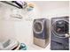 Modern laundry room with front loading washer and dryer, and storage shelves at 3941 Rothwood Ln, Harrisburg, NC 28075