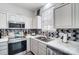 Modern kitchen featuring stainless steel appliances, white cabinets, and a sleek backsplash for stylish meal preparation at 405 Goldstaff Ln, Charlotte, NC 28273