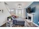 Bright living room with a plush sectional sofa, fireplace, and bright natural light streaming through the windows at 405 Goldstaff Ln, Charlotte, NC 28273