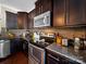 Modern kitchen featuring dark cabinetry, granite countertops, and stainless steel appliances at 430 Battery Cir, Clover, SC 29710