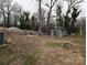 Spacious backyard with wooden shed, surrounded by mature trees and a wooden fence at 4408 Pebblebrook Dr, Charlotte, NC 28208