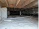 Image showing the crawlspace with wooden beams, insulation, and a white vapor barrier at 4408 Pebblebrook Dr, Charlotte, NC 28208