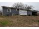 Exterior side view of the home with gray siding, an air conditioning unit, and construction materials at 4408 Pebblebrook Dr, Charlotte, NC 28208