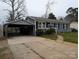 View of home and car port showing the brick exterior, concrete driveway, and convenient parking at 4408 Pebblebrook Dr, Charlotte, NC 28208