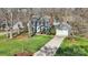 Aerial view of a charming blue two-story house with a well manicured lawn and mature trees at 4811 Dawnridge Dr, Charlotte, NC 28226