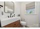 Stylish bathroom featuring shiplap walls, modern vanity, and a window at 4811 Dawnridge Dr, Charlotte, NC 28226