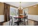 Warm dining room with wood floors, stylish light fixture, large windows, and view into the kitchen at 4811 Dawnridge Dr, Charlotte, NC 28226