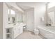 Bathroom featuring dual sinks, a jacuzzi tub, and vanity, designed with an airy feel for a serene experience at 4918 Sarah Hall Ln, Charlotte, NC 28270