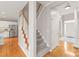 Hallway with hardwood floors leading to kitchen with stainless steel appliances and stairs to the second level at 4918 Sarah Hall Ln, Charlotte, NC 28270