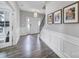 Bright foyer with hardwood floors, white wainscoting, a staircase, and decorative wall art at 5158 Mill Creek Rd, Clover, SC 29710