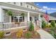 Inviting front porch with white railings, decorative plants, rocking chairs, and a view of the landscaped front yard at 5158 Mill Creek Rd, Clover, SC 29710