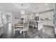 Bright kitchen featuring white cabinets, a central island with bar stools, and a cozy breakfast table at 5158 Mill Creek Rd, Clover, SC 29710