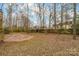 Spacious backyard features a circular brick patio, with a wooded perimeter that provides privacy at 6311 Gold Dust Ct, Charlotte, NC 28269