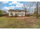 Back view of home with a brick patio area that has a chimney and windows looking into the yard at 6311 Gold Dust Ct, Charlotte, NC 28269