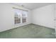 This bedroom has neutral walls, plush carpeting, and a large window at 6311 Gold Dust Ct, Charlotte, NC 28269