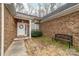 Close-up of a home's entrance featuring a white front door with a floral wreath and bench at 6311 Gold Dust Ct, Charlotte, NC 28269