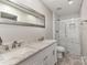 Modern bathroom featuring a double vanity, large mirror, and a walk-in shower with subway tile at 7305 Park Vista Cir, Charlotte, NC 28226