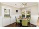 A cozy dining area features a glass table, green chairs, and a view of the outdoors through large windows at 7305 Park Vista Cir, Charlotte, NC 28226