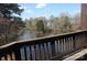 Picturesque view of the lake surrounded by lush trees from a cozy balcony at 8149 Cedar Glen Dr # 8149, Charlotte, NC 28212