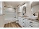 Modern bathroom with double sinks, granite countertops, white cabinets, and tub with black fixtures at 818 E Charles St, Matthews, NC 28105