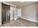 Bedroom featuring wood-look floors, a closet with sliding barn door, and neutral paint at 818 E Charles St, Matthews, NC 28105