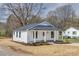 Charming home featuring a covered front porch, white siding, and a dark gray roof at 818 E Charles St, Matthews, NC 28105