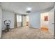 Spacious bedroom showcasing neutral carpet, a window with drapes, and connecting doorways to other rooms at 84 Lake Concord Ne Rd # S, Concord, NC 28025